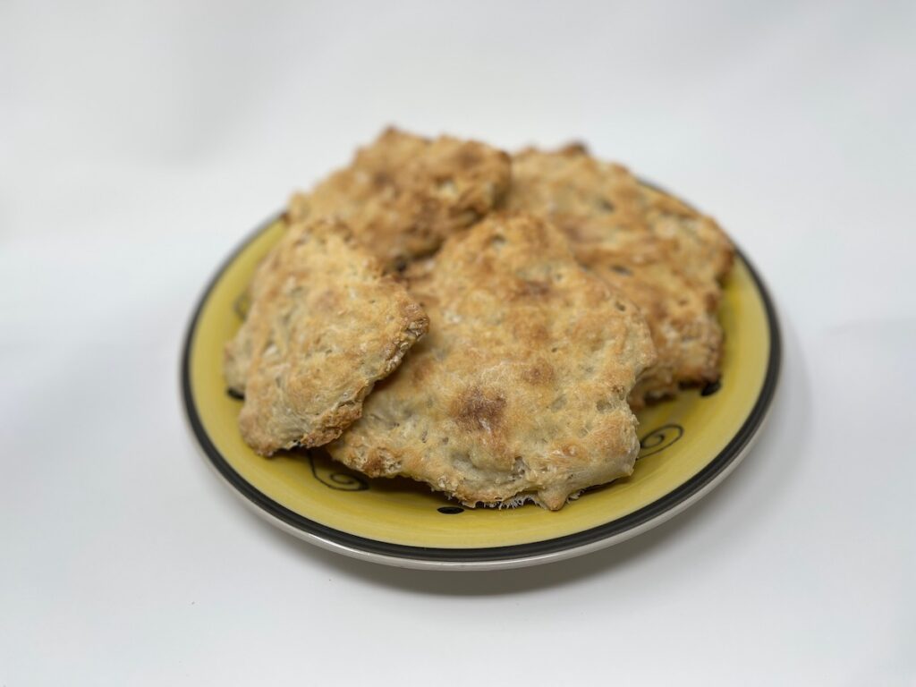 A yellow plate holds a few irregularly shaped, golden-brown baked items reminiscent of crispy Passover matzo.