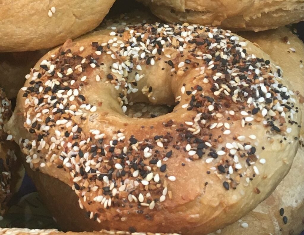 Close-up of a New York bagel, perfectly topped with sesame seeds, poppy seeds, and seasonings.