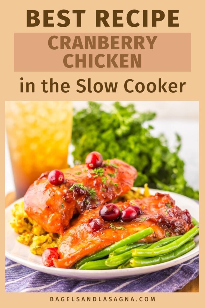 A plate of slow cooker cranberry chicken with green beans and garnish, accompanied by a drink in the background. Text: "Best Recipe: Cranberry Chicken in the Slow Cooker" with website link below.