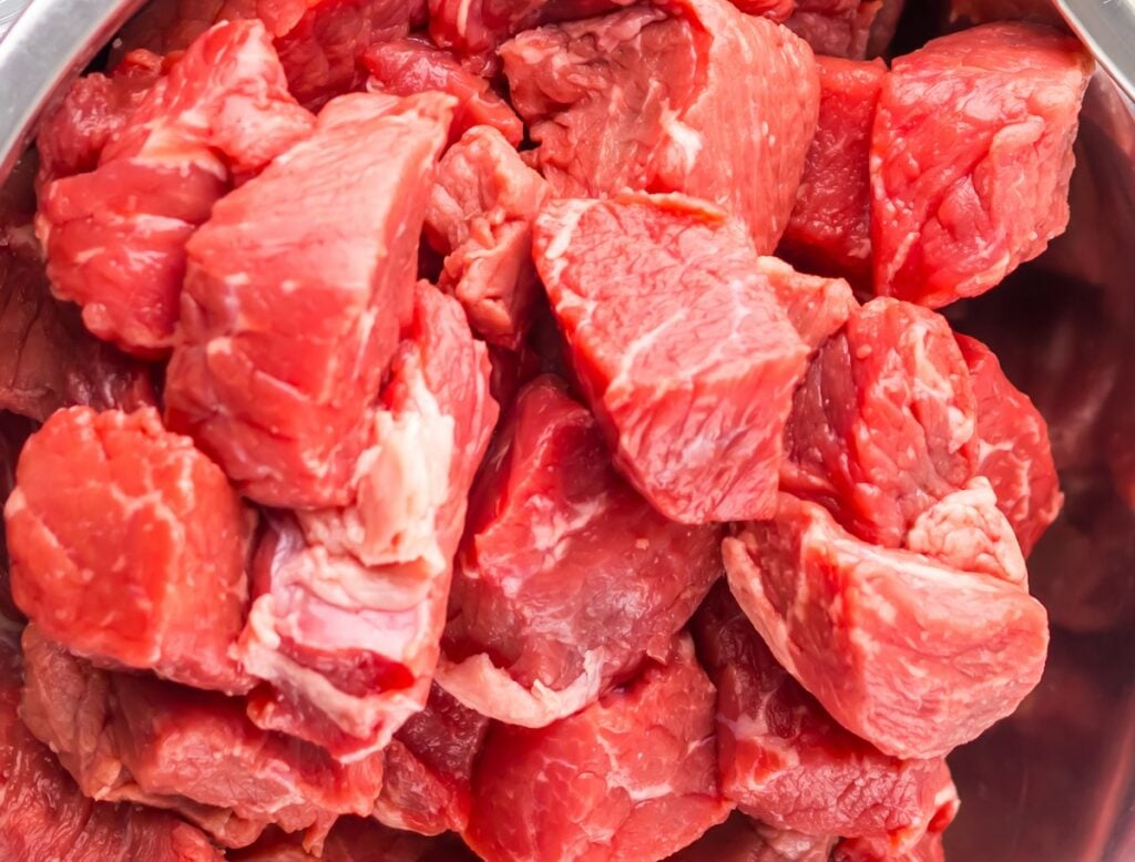 A close-up of raw, cubed beef pieces in a bowl.