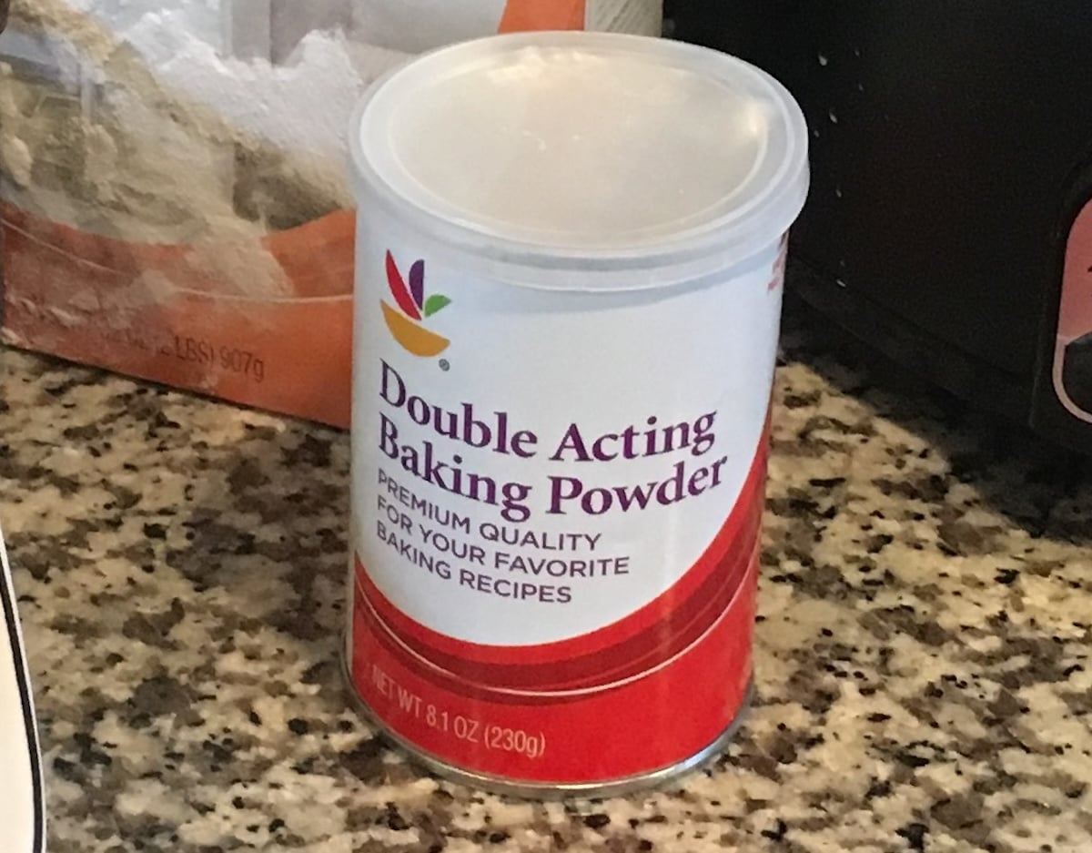 A can of store-brand double acting baking powder sits on a kitchen counter, ready to be transformed into delightful treats. For those adventurous bakers, consider exploring baking powder substitutes for a twist in your recipes.