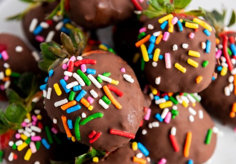 Close-up of strawberries coated in chocolate and decorated with colorful sprinkles.