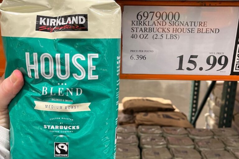 Person holding a 40 oz. Kirkland Signature House Blend coffee bag, touted as the best ground coffee for its rich flavor, priced at $15.99 near a store shelf displaying Starbucks coffee.