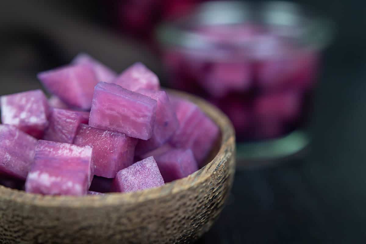 A bowl filled with cubed purple blueberry pickled radishes.
