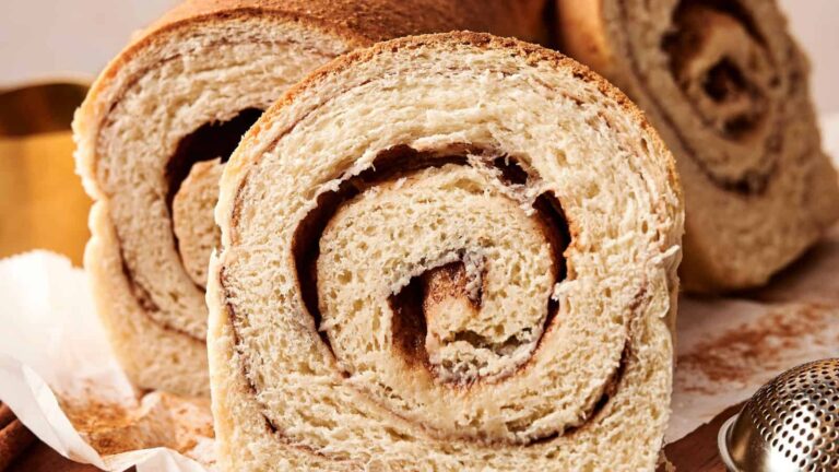 Close-up of sliced cinnamon swirl bread, showing the spiral layers of dough and cinnamon filling.