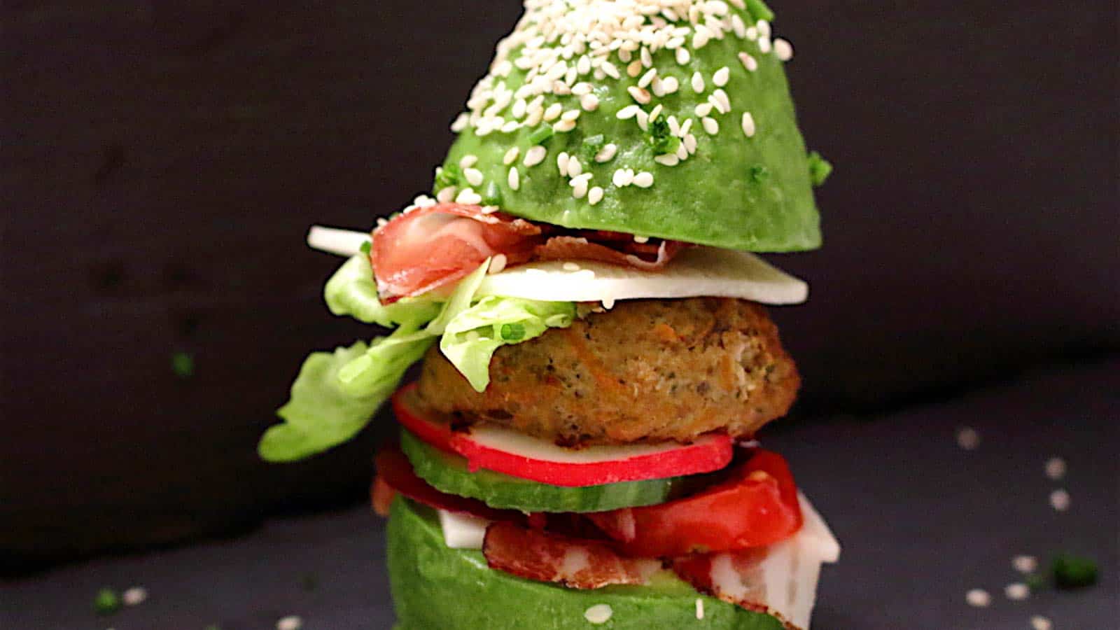 A burger stuck in between avocado as buns.