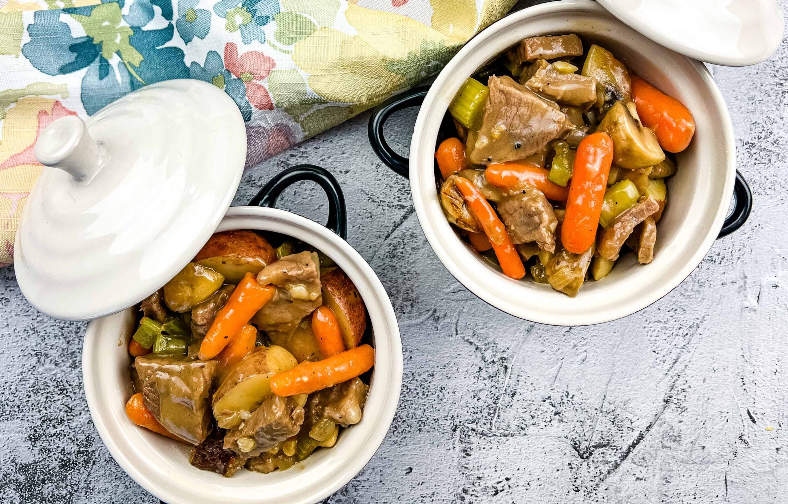 Two bowls of leftover roast beef stew on a table.
