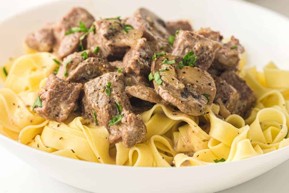 A plate of Slow Cooker Beef Stroganoff garnished with chopped parsley.