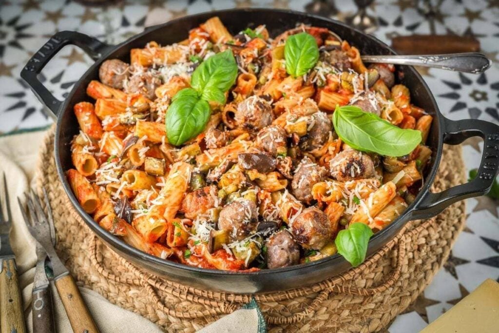A pan of pasta with meatballs and cheese.