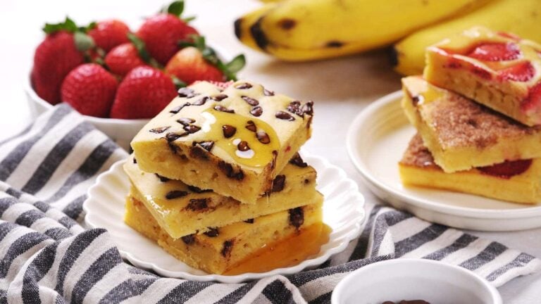 Three chocolate chip banana bars stacked on a white plate.