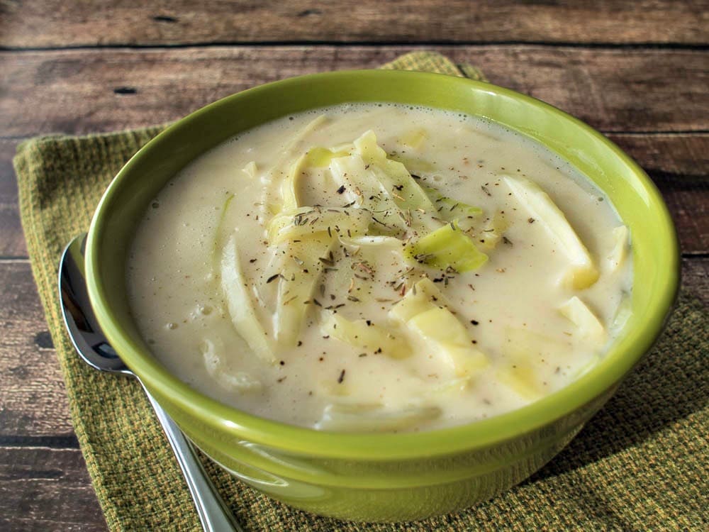 Colcannon Soup in a green bowl with a spoon.