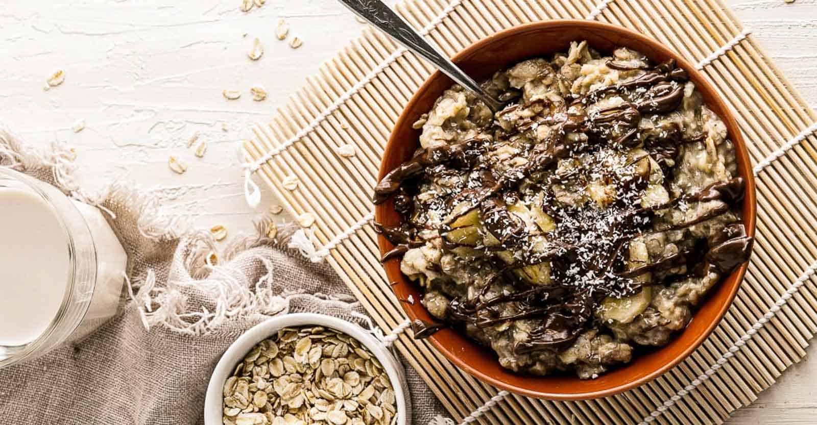 A bowl of banana oatmeal and a glass of milk.