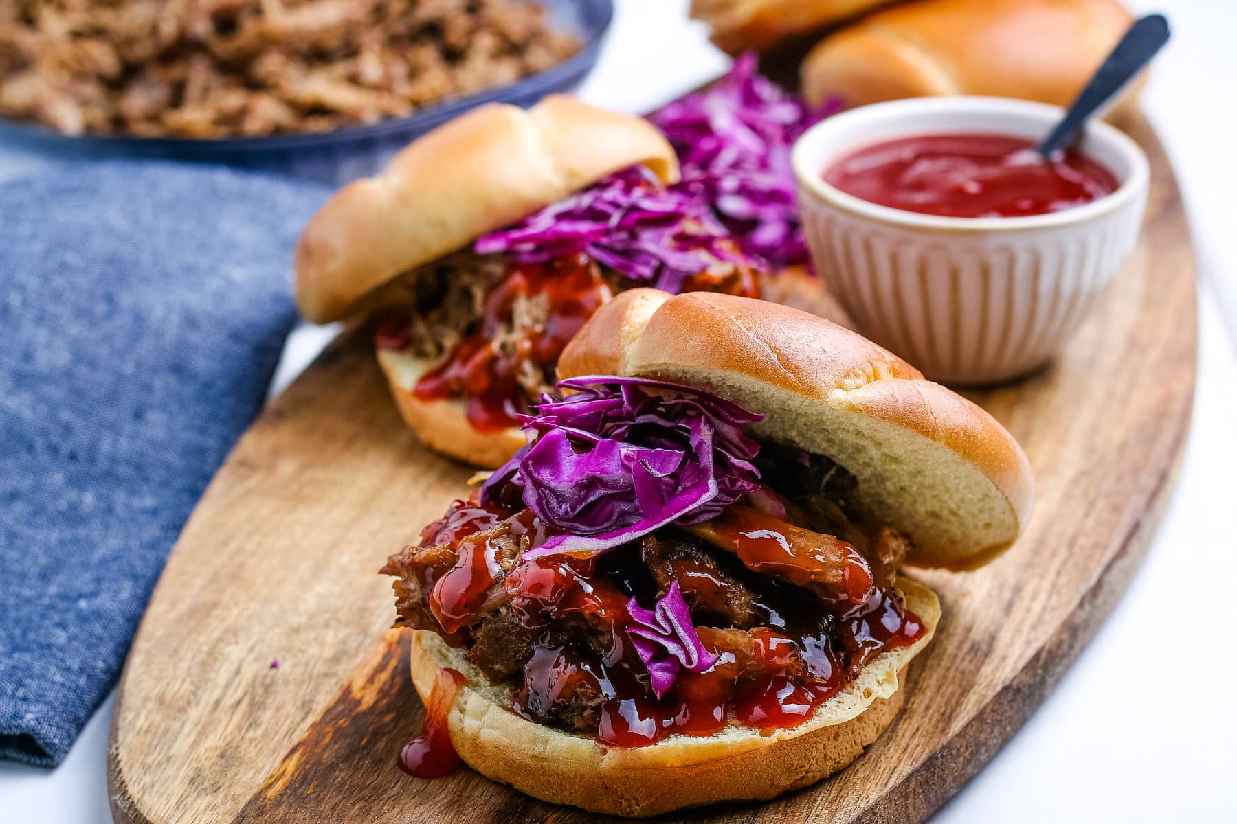 Pulled pork on a bun with sauce and cabbage.