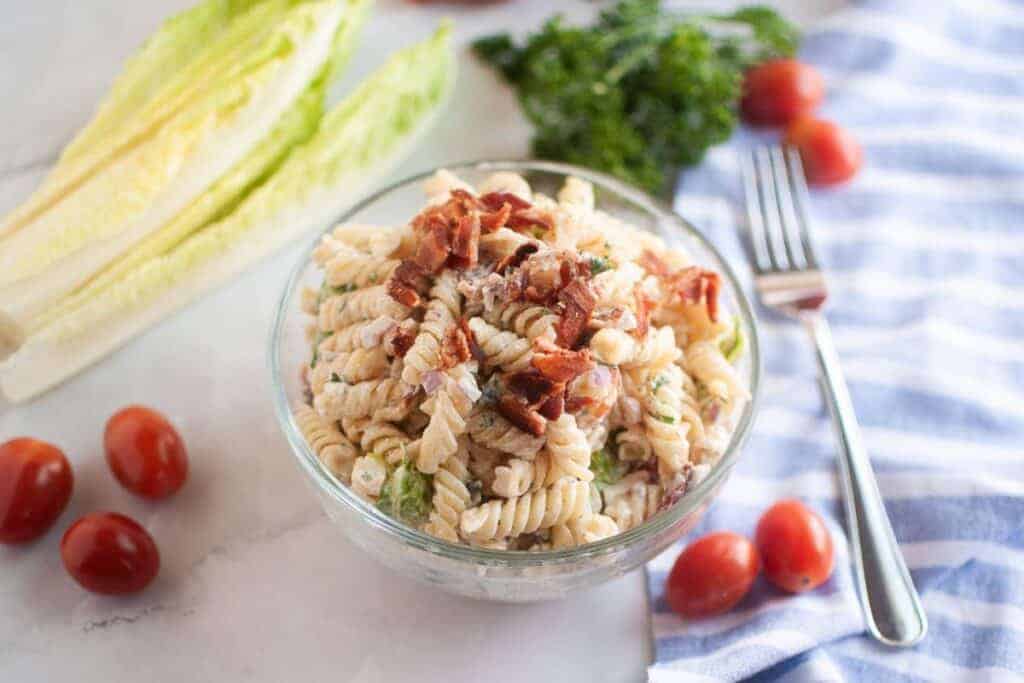 Overhead shot of a glass bowl filled with BLT pasta salad.