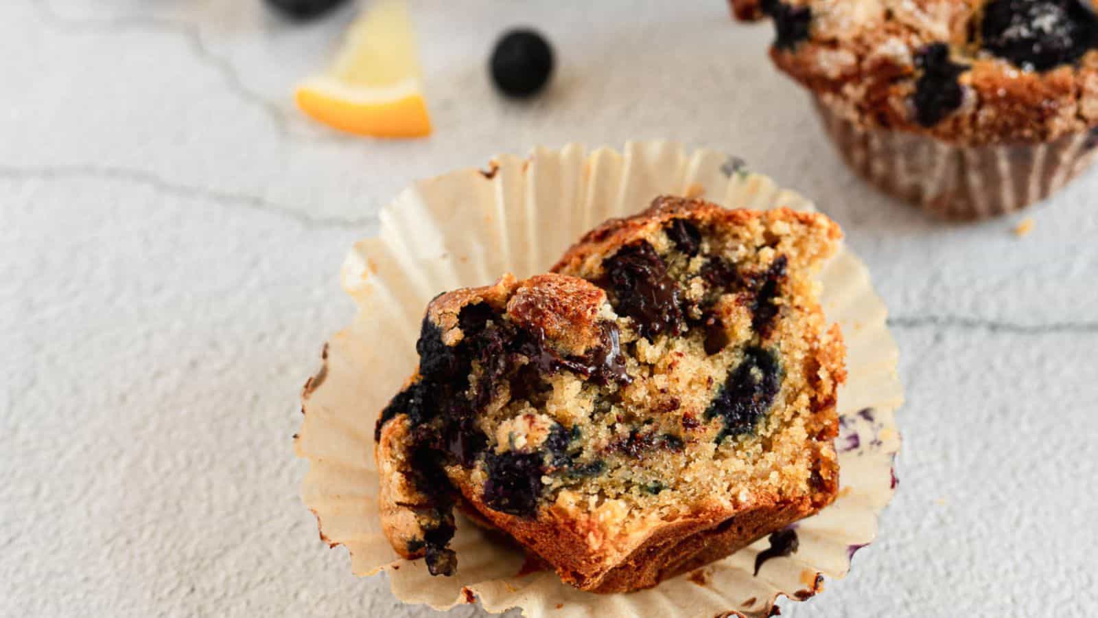 Lemon and blueberry muffin halves with lemon and blueberries.