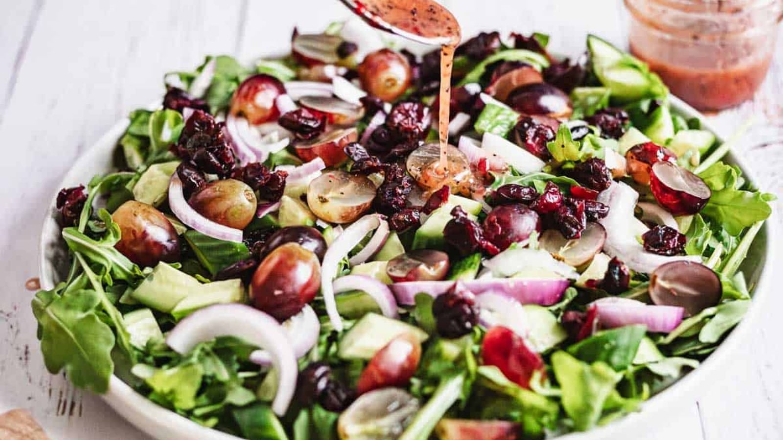 Goat cheese salad with greens, roasted beets, and candied walnuts on a plate.