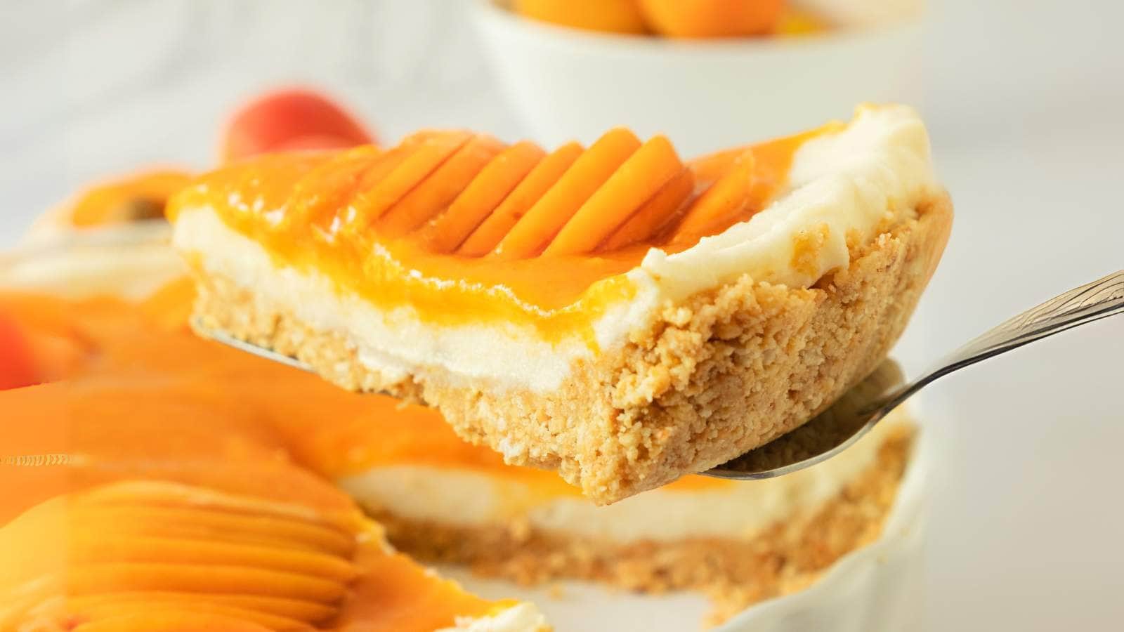A close-up of a slice of apricot tart with a crumbly crust, creamy filling.