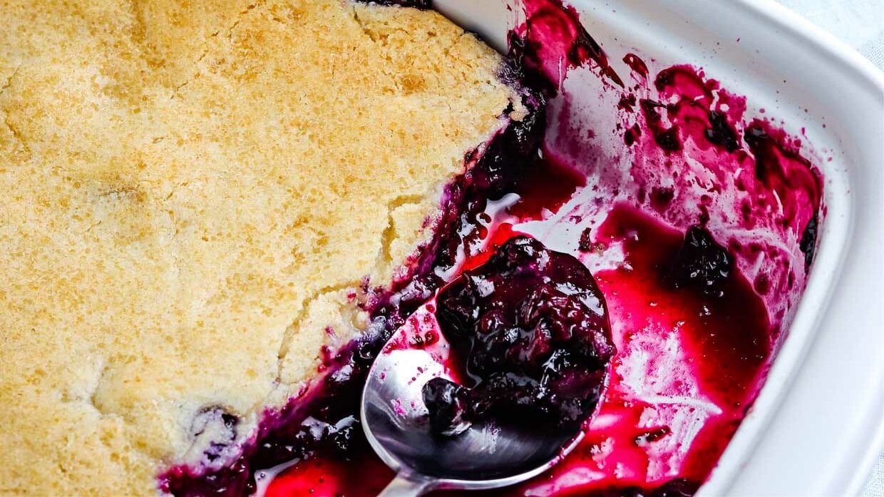 Blueberry cobbler topped with a scoop of vanilla ice cream.