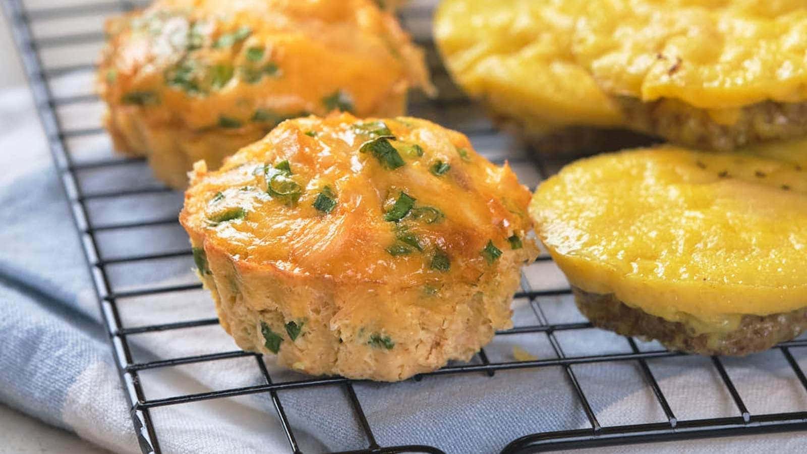 Golden, cheesy muffins with herbs cool on a wire rack, ready to be served.