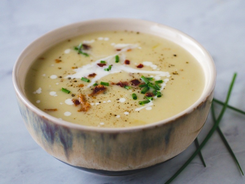 Bowl of potato soup with bacon and chives.