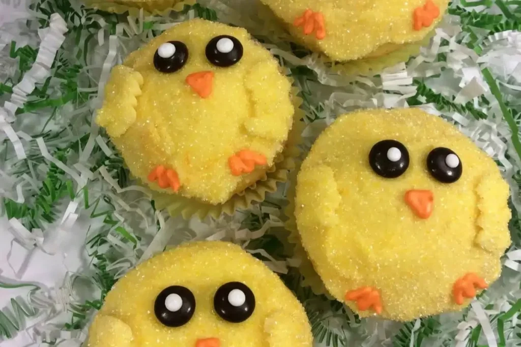 Baby chick Easter cupcakes decorated with yellow frosting and candy eyes.
