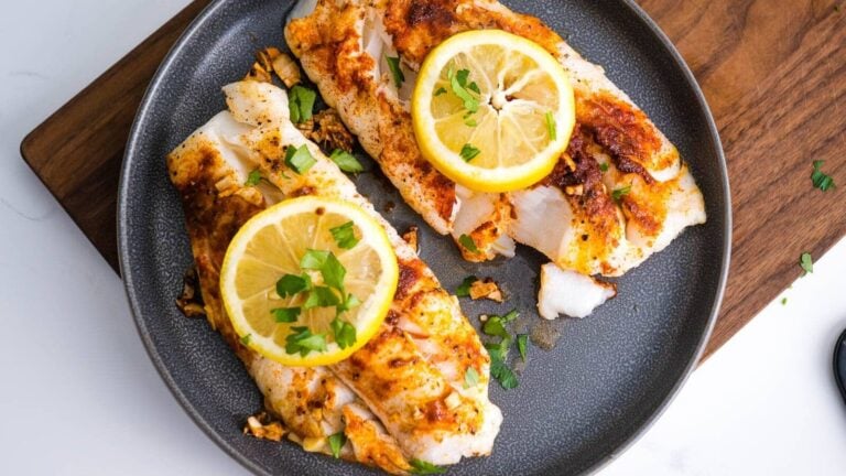 Air fryer cod fillets without breading topped with lemon and herbs.