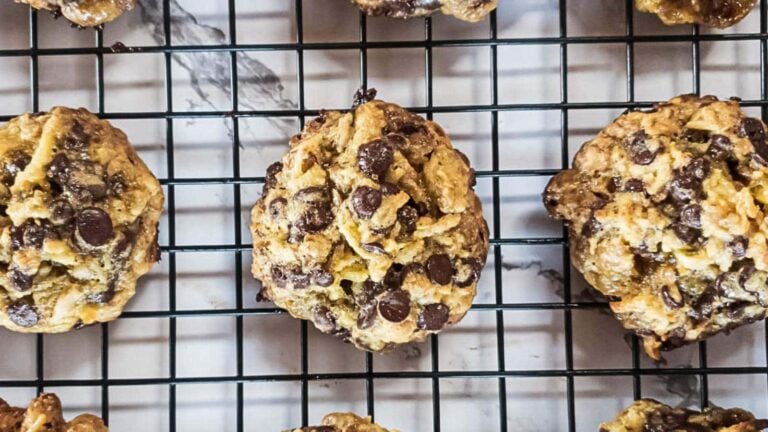 Cookies with chocolate chips cooling on a wire rack.