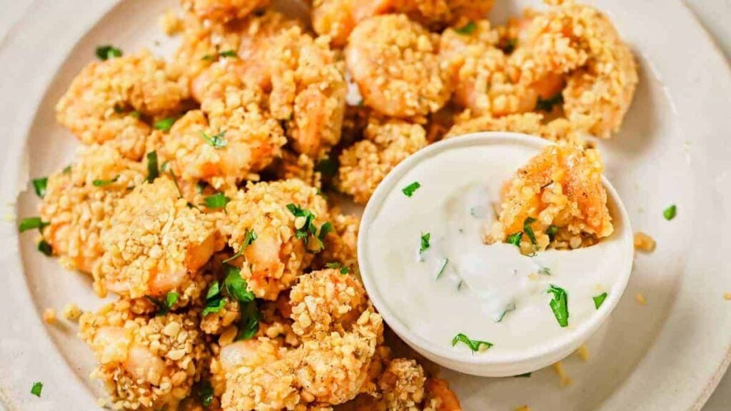 A white bowl filled with crispy battered popcorn shrimp.