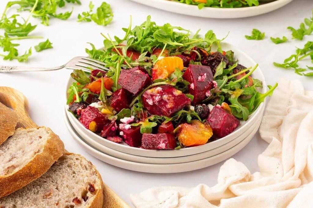 Appetizer beet salad with arugula and pomegranate.