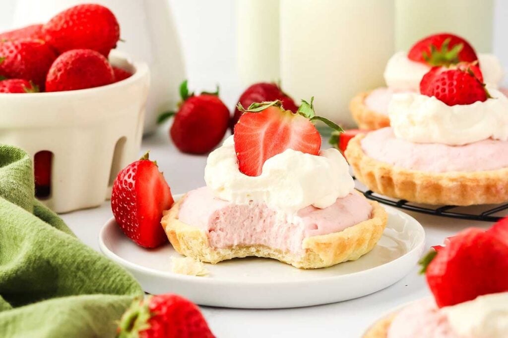 Strawberry mini tarts with whipped cream and strawberries.