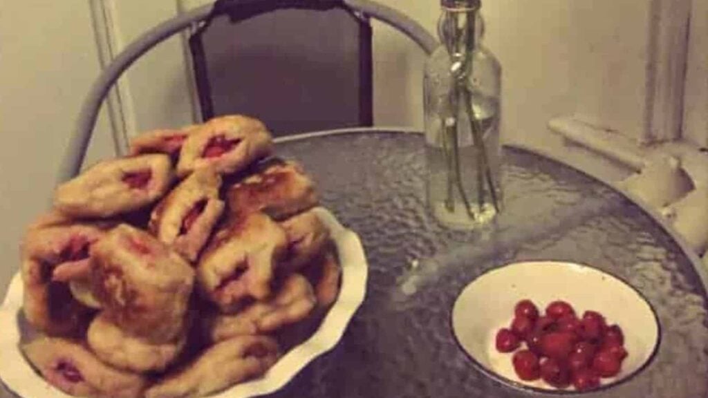 Sour Cherry Sufganiyot, Or Doughnuts next to a bowl of cherries,
