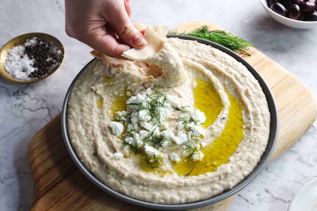 Dipping a pita into a White Bean Hummus.